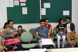 Sala com pessoas sentadas em cadeiras aguardando atendimento