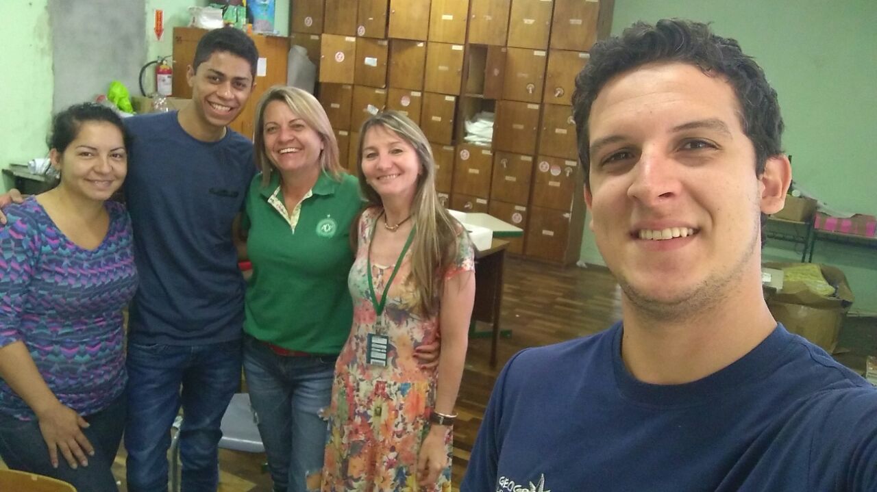 Estudante faz selfie na qual aparecem, em segundo plano, outros dois estudantes, a professora da escola e a professora da UFFS abraçados e sorridentes