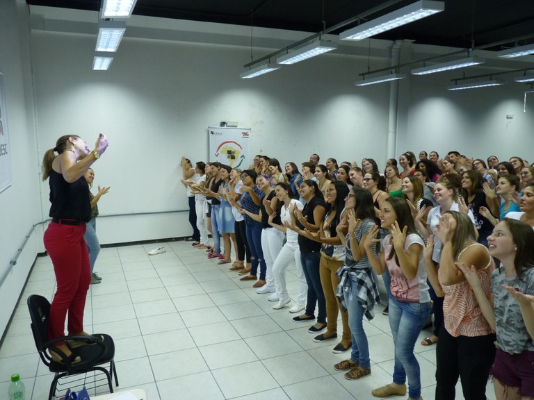 Professora realizando regência de um coral 