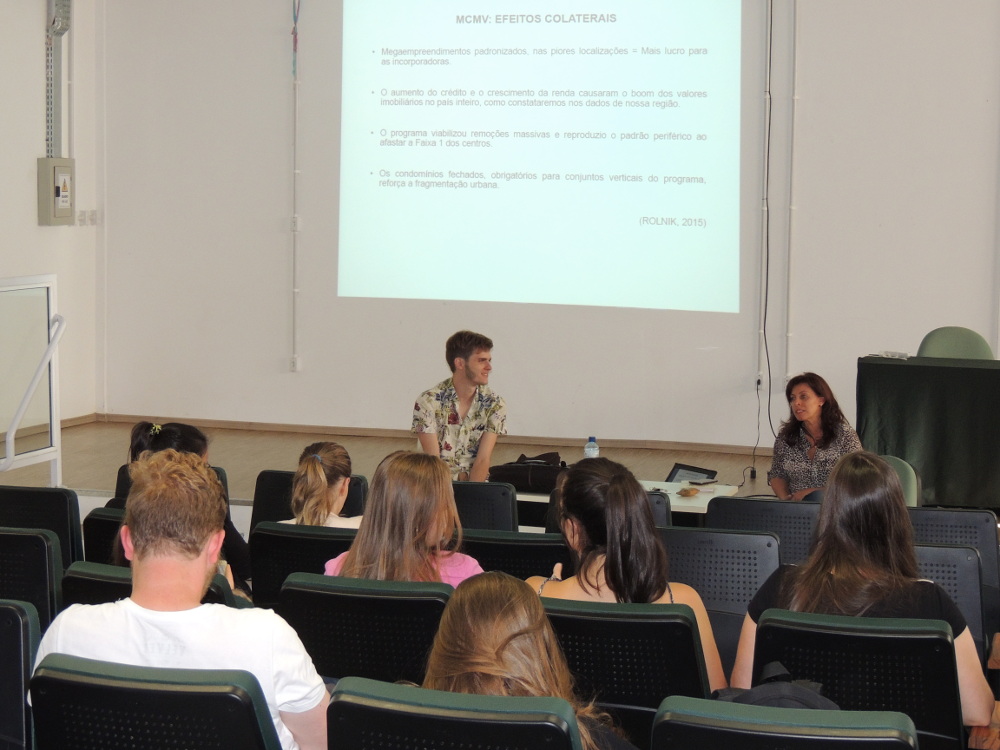 Foto da mesa-redonda do curso de Arquitetura, com dois palestrantes falando para o público