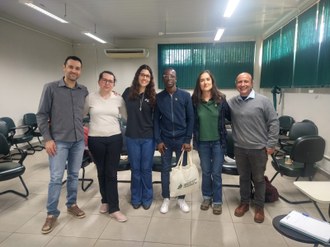 Foto mostra seis pessoas em pé, posando para a foto.
