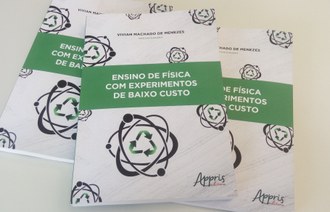 Capas de três livros sobrepostos sobre uma mesa