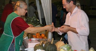 Duas pessoas, em situação de compra e venda, na feira agroecológica da UFFS