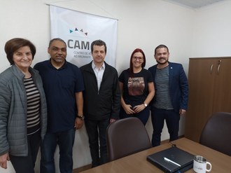 Três homens e duas mulheres de pé posando para a foto