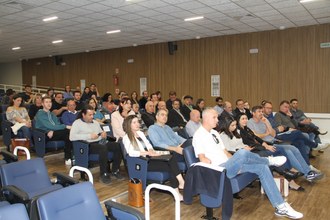 várias pessoas sentadas em cadeiras num auditório