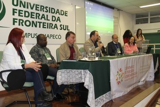 Pessoas sentadas atrás de uma mesa