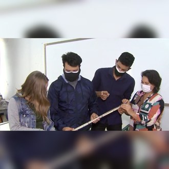 Foto de quatro pessoas segurando um cilindro