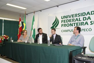 quatro pessoas sentadas atrás de uma mesa