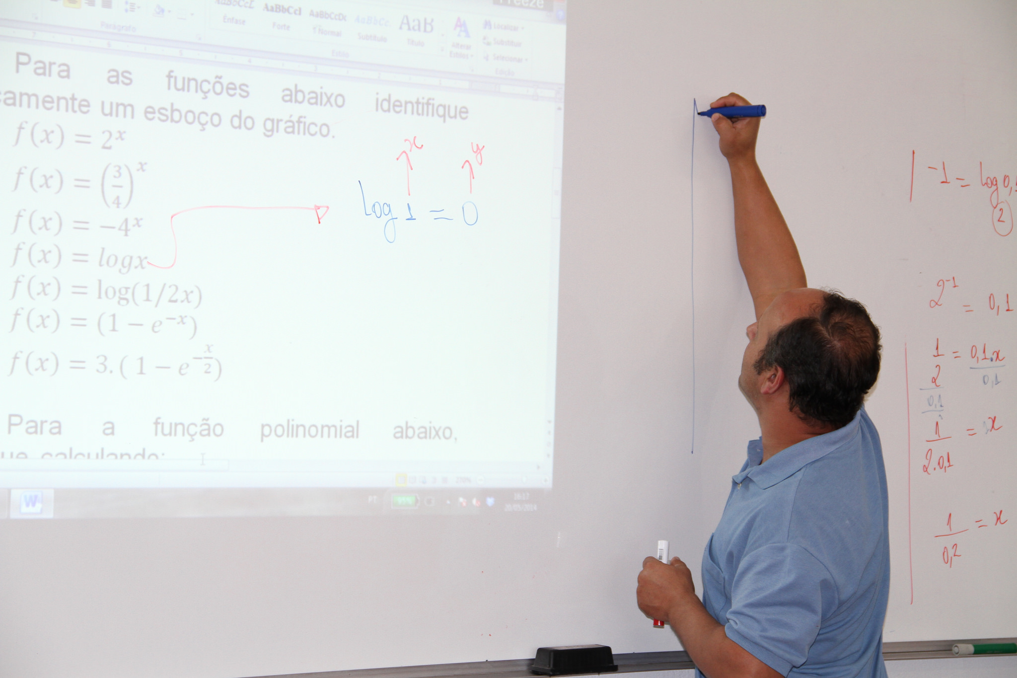 Professor escrevendo no quadro branco de uma sala de aula